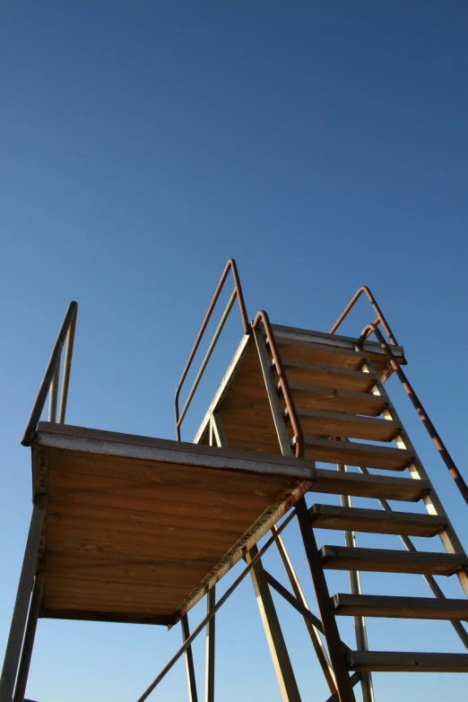 an old lifeguard tower with a blue sky in the background