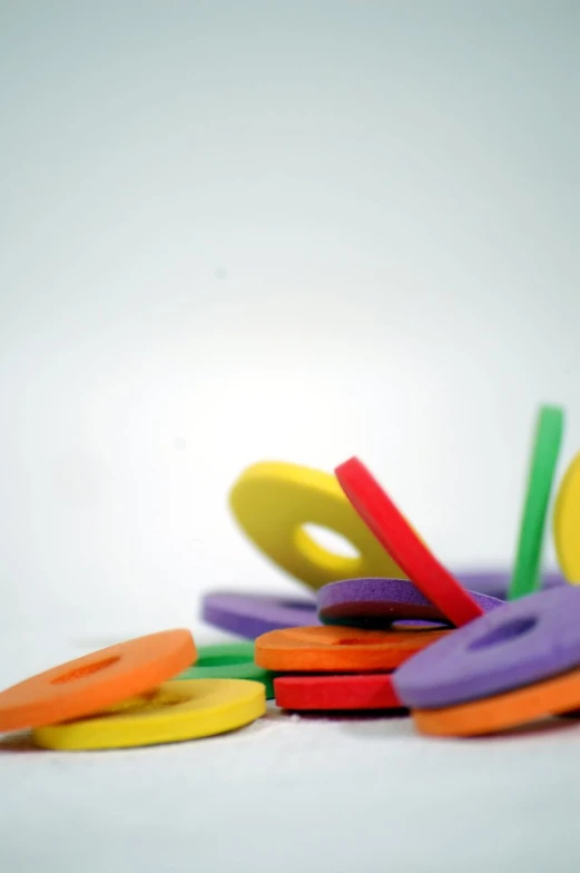 brightly colored plastic letters sit together on a white surface