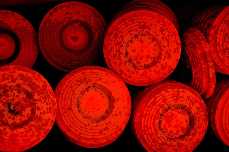 several orange circles in red light on the side of a red wall