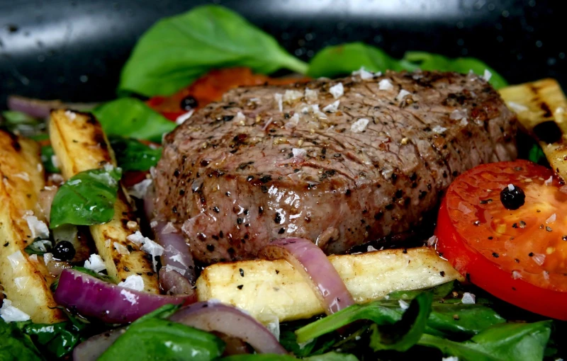 steak, potatoes and tomato on a plate