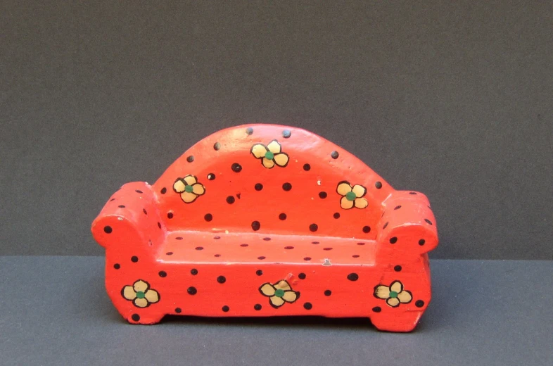 an orange toy sofa with yellow flowers on the seat