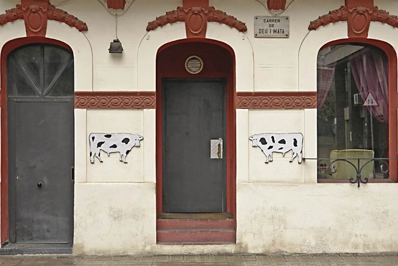 an old building with painted cows on the door