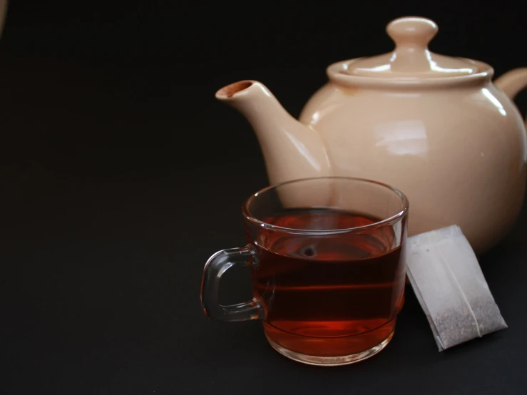 a mug of tea next to a tea bag