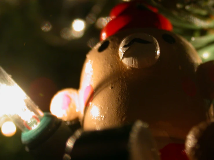 a teddy bear sitting beside a lit candle