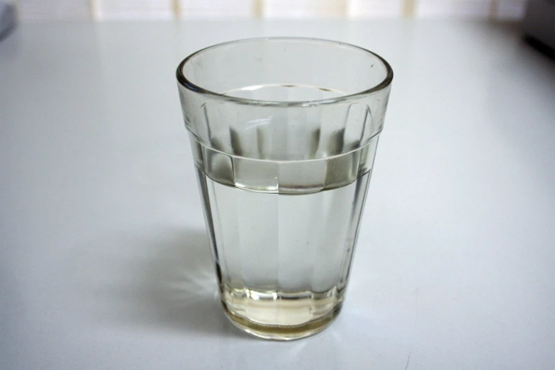 a s glass filled with liquid sitting on a white counter