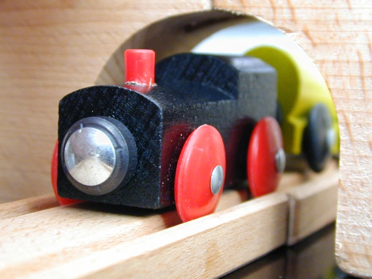 a toy train on the wooden surface and reflected in a mirror