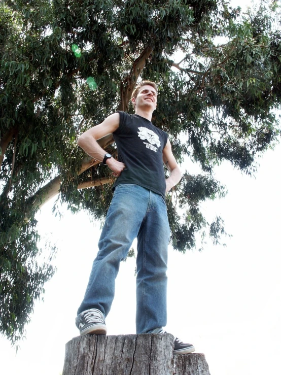 the boy is standing on top of a large wooden object