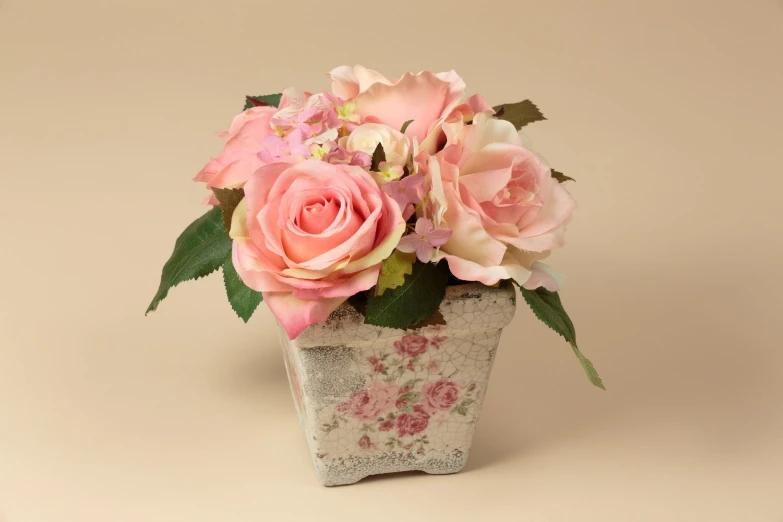 a small vase with pink roses in it