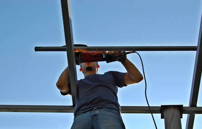 a man standing in front of a cross and holding a bottle