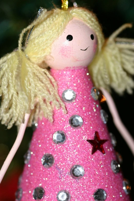 a pink christmas tree decoration with a gold angel