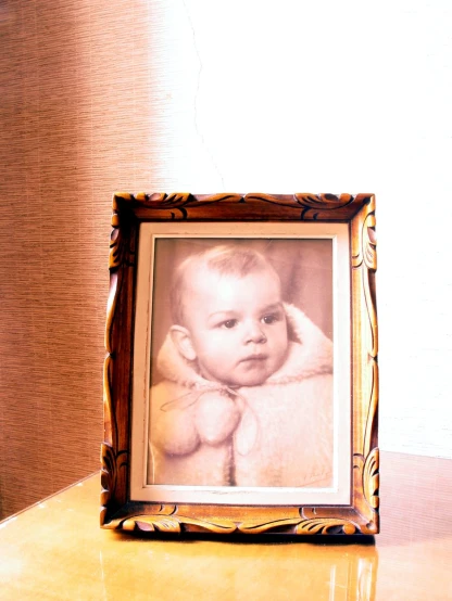 a po frame is on a table with a baby's head