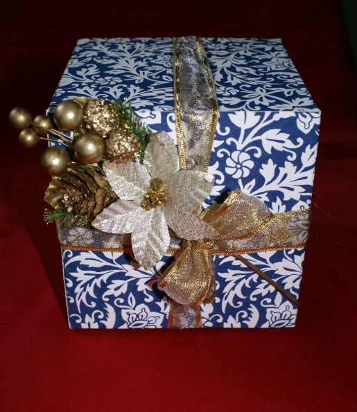 a decorated holiday box on a red and blue table cloth