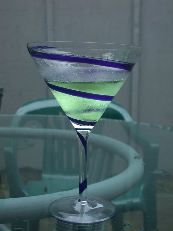 a blue and white striped drink in a coupe glass