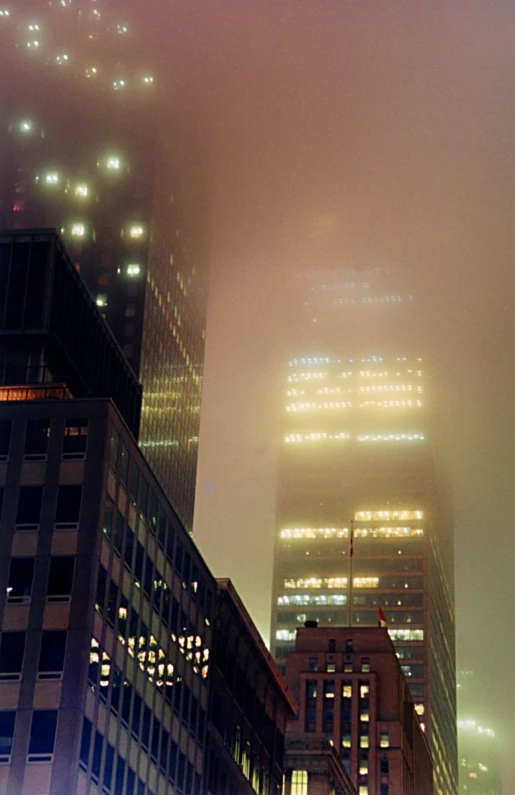 fog covers skyscrs in the city at night