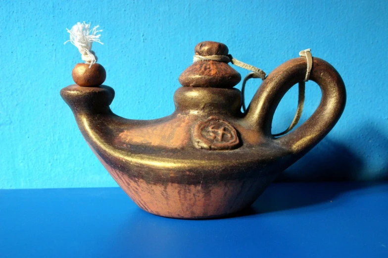 the metal teapot with a couple of little ornaments on it's lid