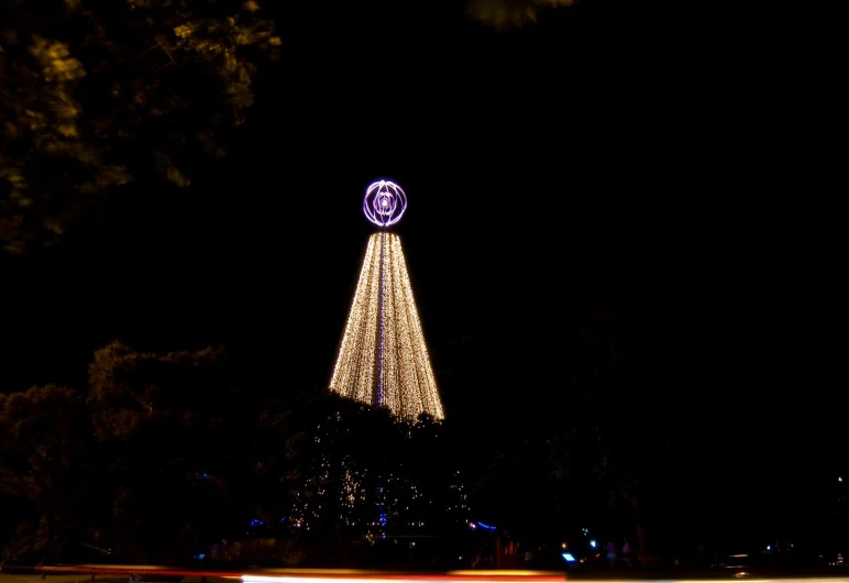 a white lit christmas tree in a city with lights