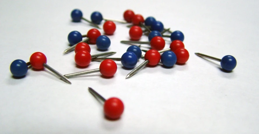 red, white and blue pin heads are laying on pins