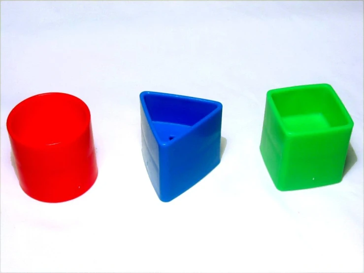 three plastic cups with different color shapes on the floor