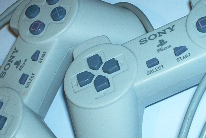 three video game remotes, four of which have ons and controls