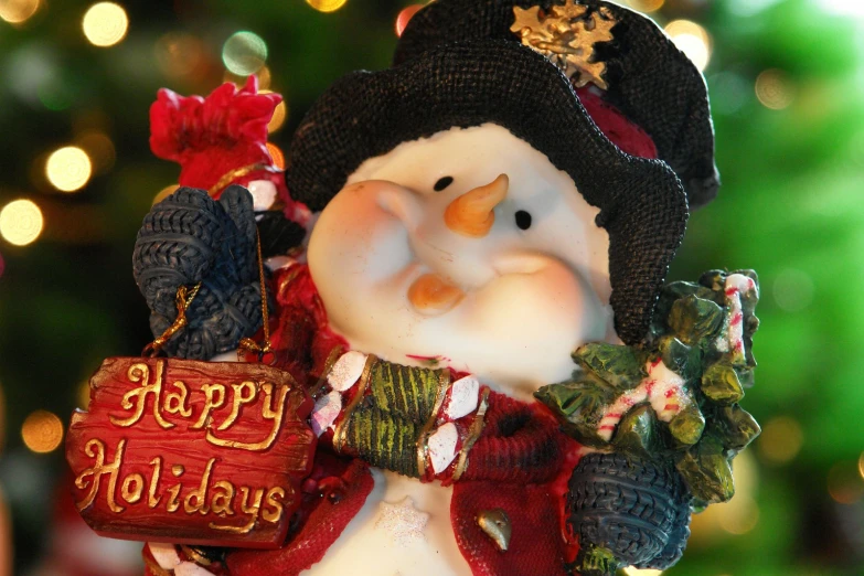a merry holiday ornament has an image of a snowman wearing a hat