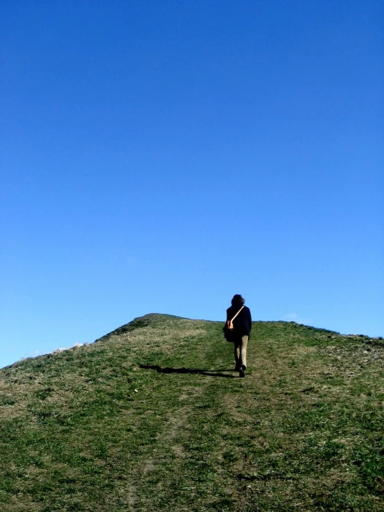 a man is standing in the grass and wearing a coat