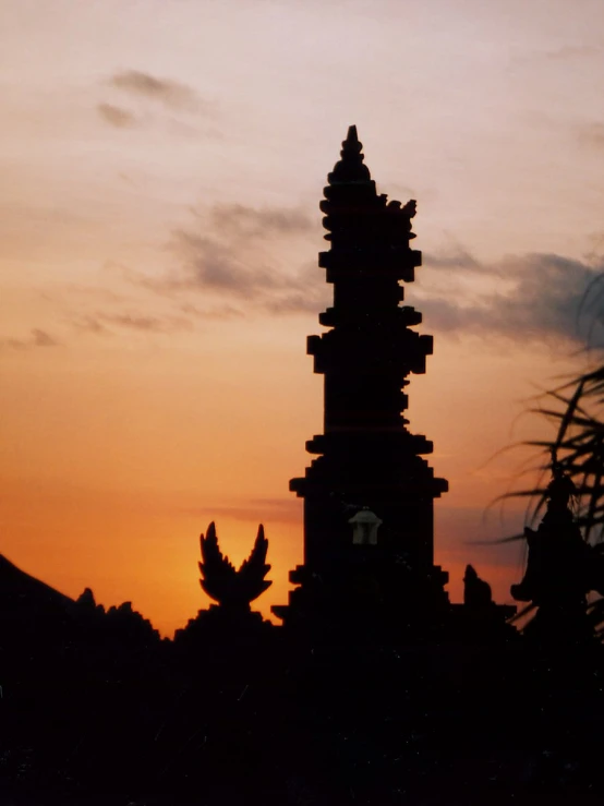 a tall tower with a clock displayed at sunset