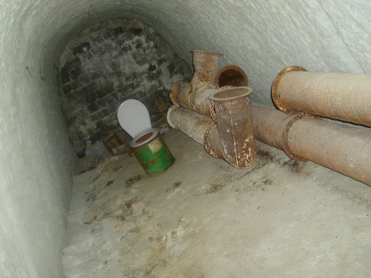 a toilet is surrounded by pipes in the bat