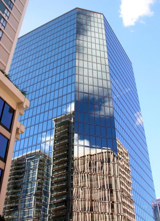 many buildings near one another reflecting a blue sky