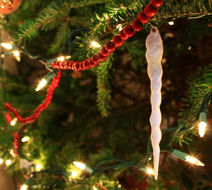 a white snow cone shaped ornament hanging on a tree