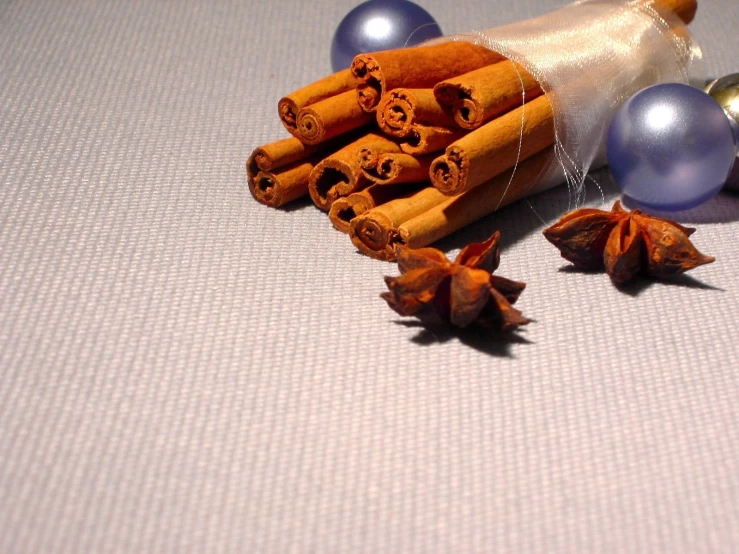 cinnamon sticks are scattered around some blue, glass beads