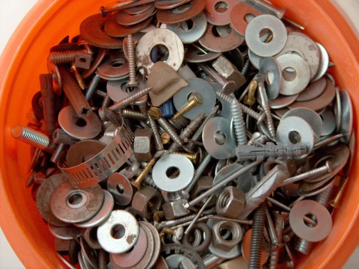 there is a bowl full of small assorted metal items