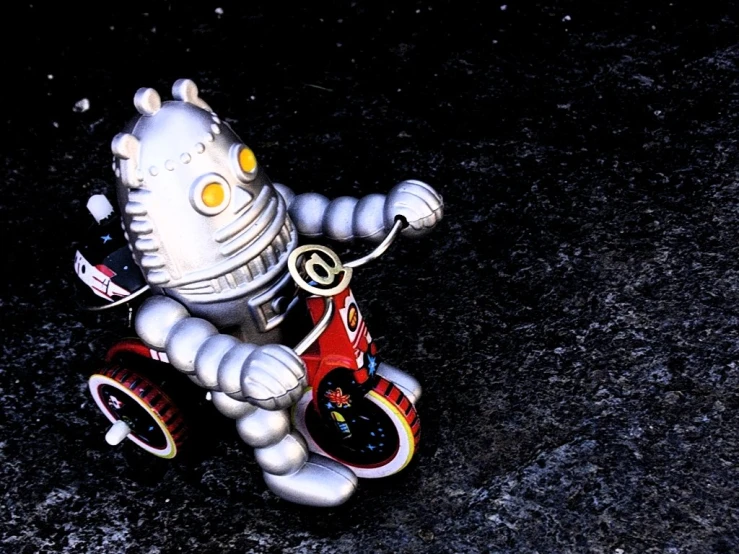 a robot riding a tricycle sitting in the dark