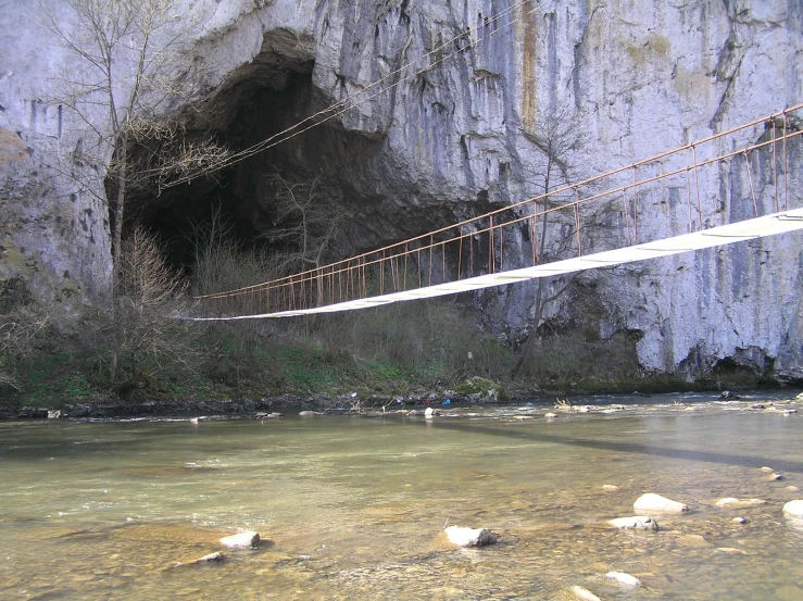 suspension and bridge hanging from a cliff over a river