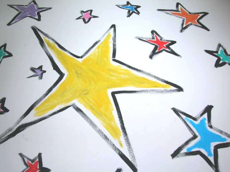 drawing of a star and multicolored stars on a white paper background