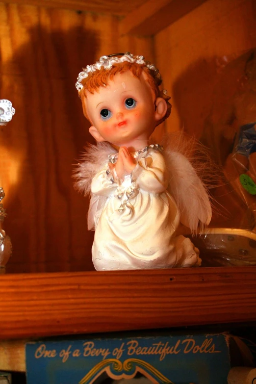 a cute doll sitting next to an old fashioned glass bottle