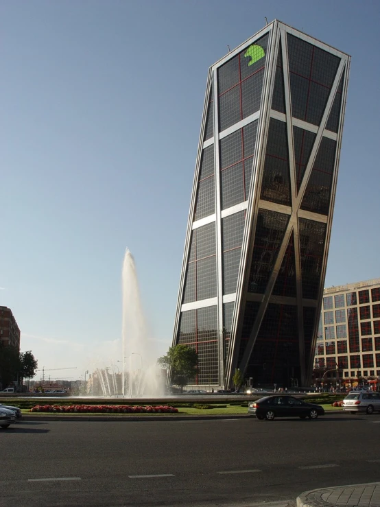 a big tall building with a water fountain near the street