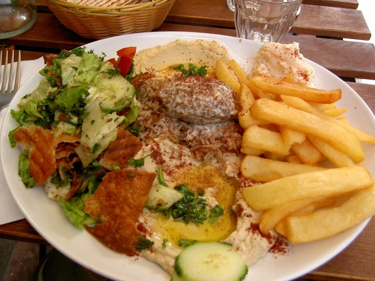 a white plate topped with french fries and mixed vegetables
