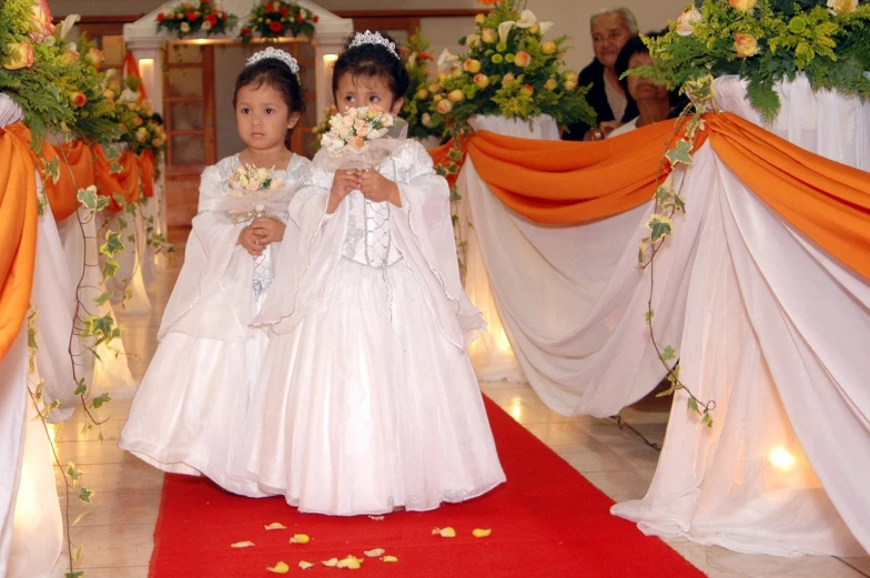 two children standing side by side at a formal wedding