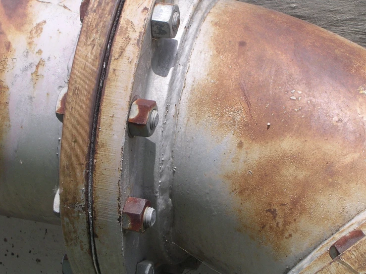 an old rusted out metal tank sitting on top of concrete