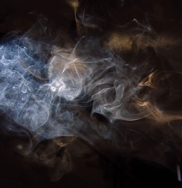 smoke moves through the dark, darkened image