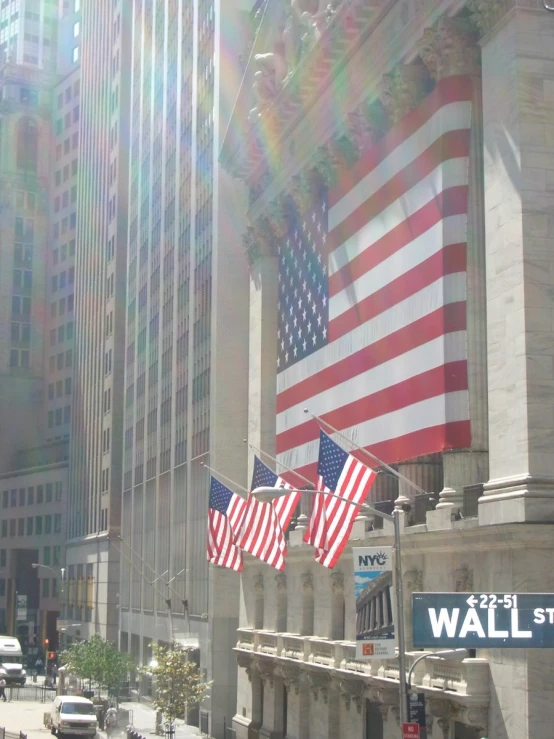 a group of american flags flying in the wind on a sunny day