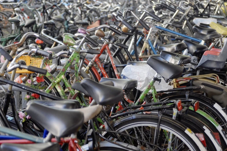 a lot of bicycles parked together with different colors