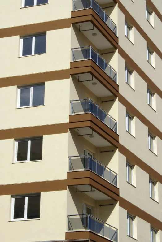 a close up of a tall beige building with balconies