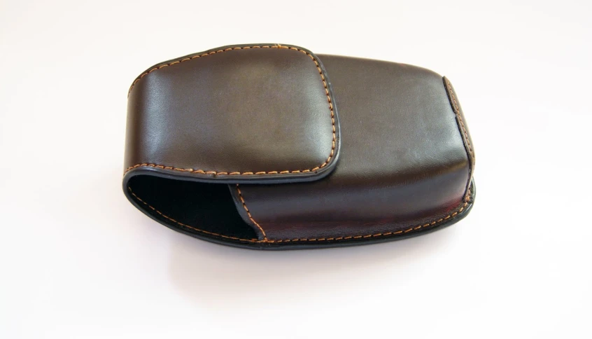 two leather cases with tan stitching sitting on a table