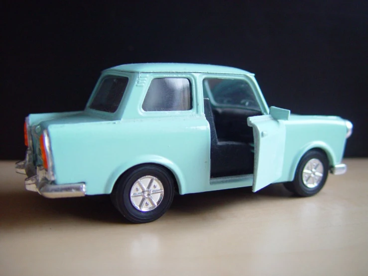 a blue and silver toy truck sitting on a wooden table