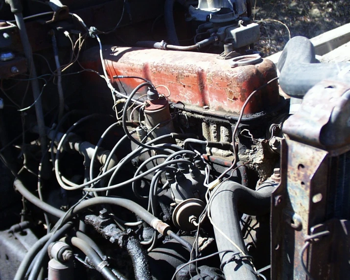 an old rusted engine with its wires and harnesses