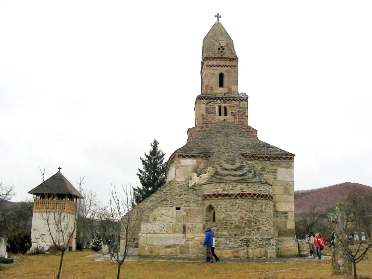 a small stone church sits in the middle of a field