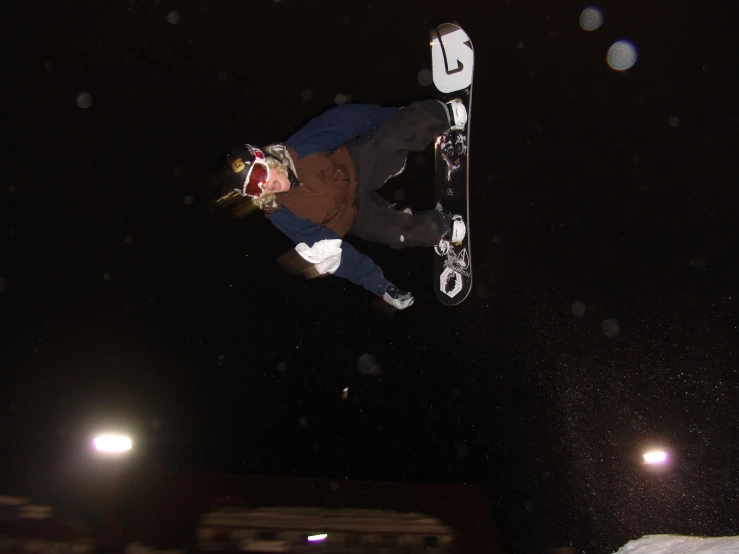 a man doing a trick on his snowboard in the air