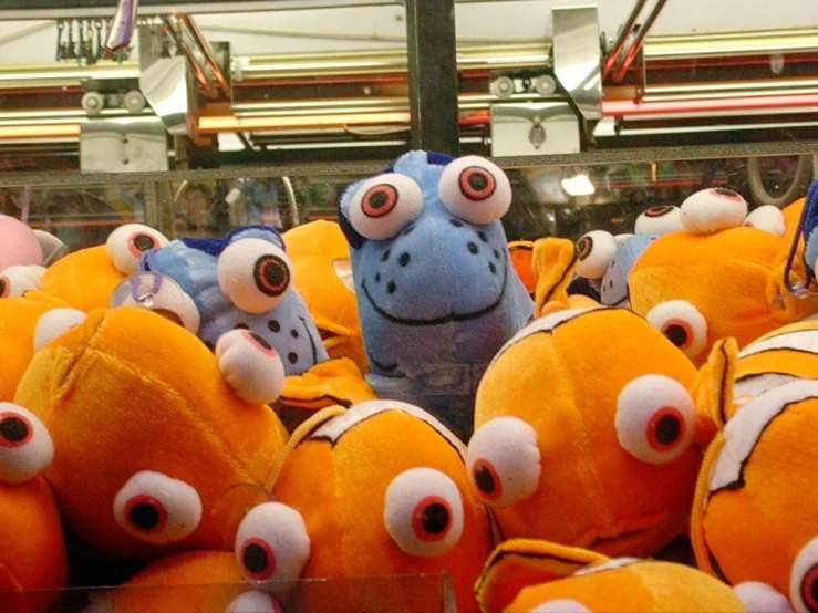 there is a lot of yellow stuffed animals with different eyes