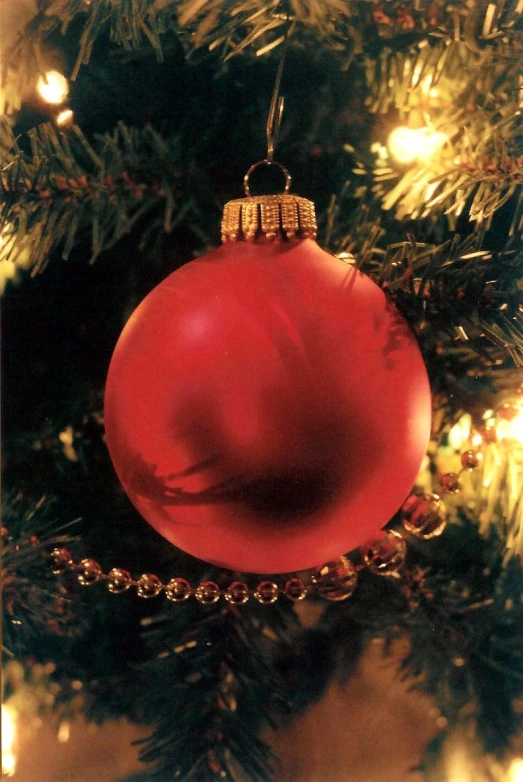 a christmas tree with a red ball and chains on it